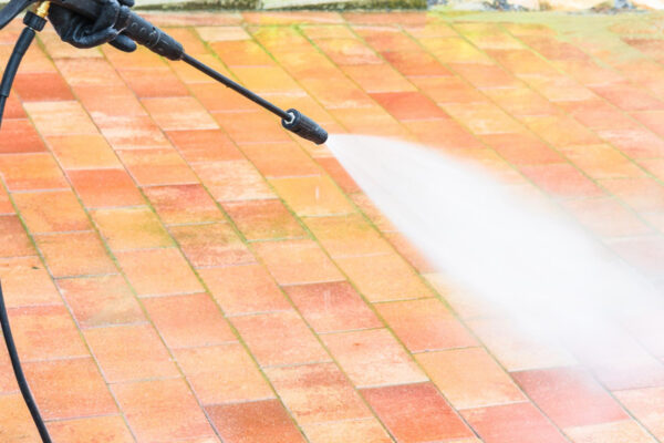 worker washing exterior of house